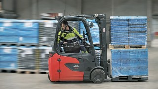 Ein Mitarbeiter von DB Schenker fährt rückwärts auf dem Linde Elektrostapler E16 Ein Mitarbeiter von DB Schenker fährt rückwärts auf dem Linde Elektrostapler E16