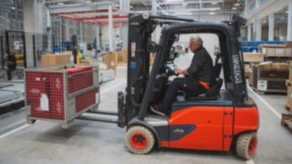Ein Linde Elektrostapler transportiert eine Gitterbox