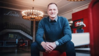 Zwei Geschäftsleute diskutieren über innovative Intralogistiklösungen, die die Zukunft der Intralogistik und die Kundenorientierung im Vertrieb symbolisieren. 