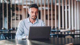 Projektmanager steuert fokussiert Projekte an seinem Laptop im internationalen Umfeld bei Linde. 