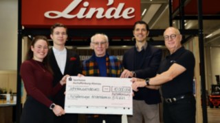 Spende des Staplercup hilft e. V. an Aschaffenburger Kinderträume Fünf Personen stehen zusammen und halten einen großen Scheck in der Hand, der von Linde MH an Aschaffenburger Kinderträume adressiert ist mit einer Summe von 10.000 Euro.
